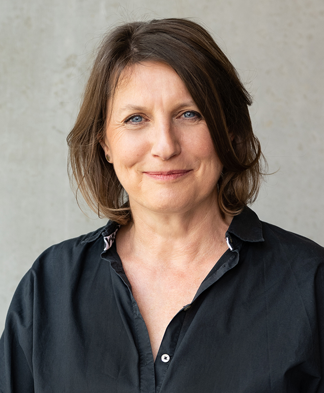 Porträt von Anke Illing vor einer Betonwand