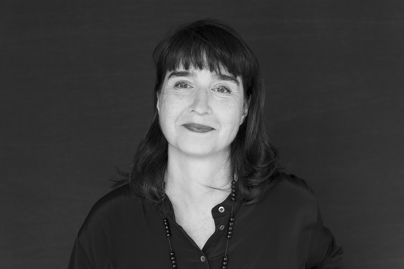Schwarz-Weiß-Porträt von Laura Fogarasi-Ludloff mit dunklem Pony und Halskette